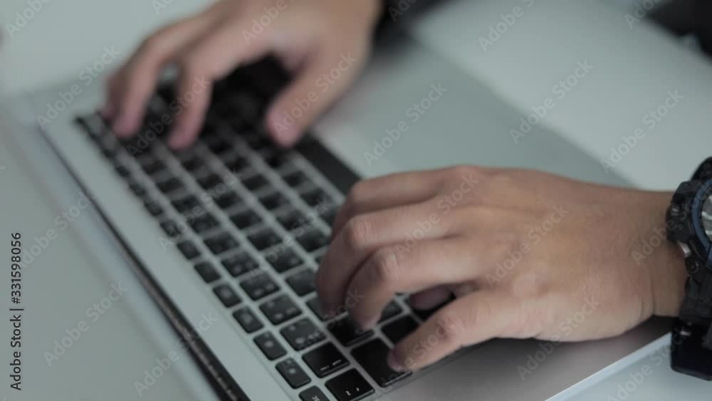 A close up of the hand of a business man on a laptop keyboard. A close up of the hand of a business man on a laptop keyboard.