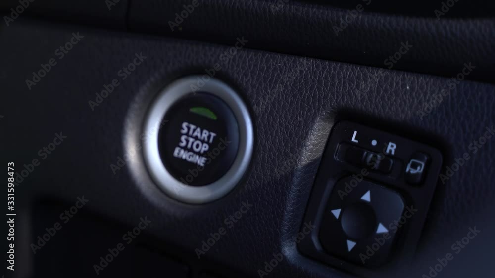 The hand is pushing start and stop engine of vehicle. The hand is pushing start and stop engine of vehicle.