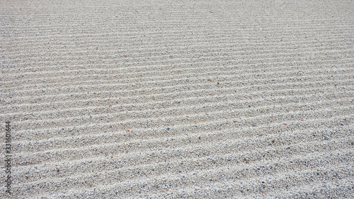 Texture of small pebbles, raked into parallel lines.