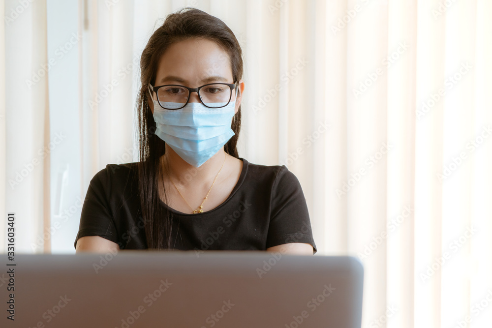 working from home during Coronavirus or Covid-19 outbreak, woman with face mask protection while working at home working from home during Coronavirus or Covid-19 outbreak, woman with face mask protection while working at home