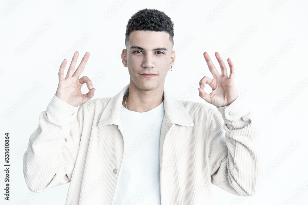 Serious man showing ok sign. Portrait of handsome confident young man showing ok symbol with hands and looking at camera. Gesture concept Serious man showing ok sign. Portrait of handsome confident young man showing ok symbol with hands and looking at camera. Gesture concept