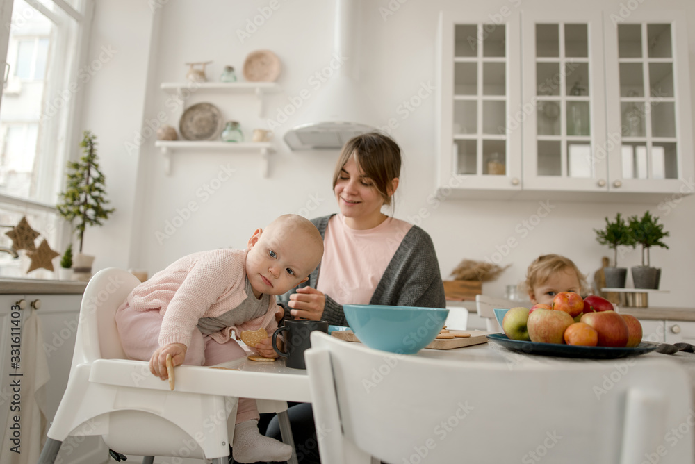 A young mother spends time with her little daughters at home. A young mother spends time with her little daughters at home.