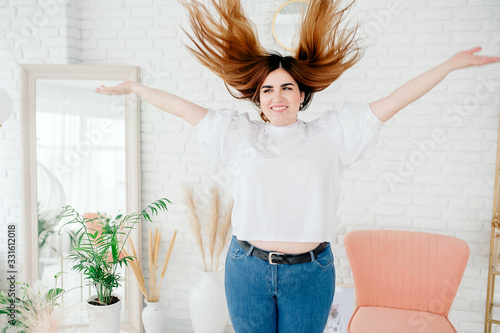 Photos Happy plus size model in jeans and white t-shirt, tosses hair lifestyle