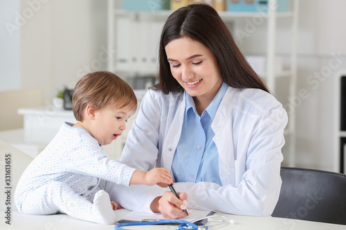 Pediatrician examining little baby in clinic