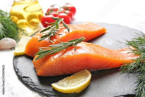 Raw salmon fillet with lemon on slate plate