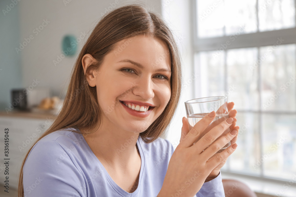 Beautiful young woman drinking water at home Beautiful young woman drinking water at home