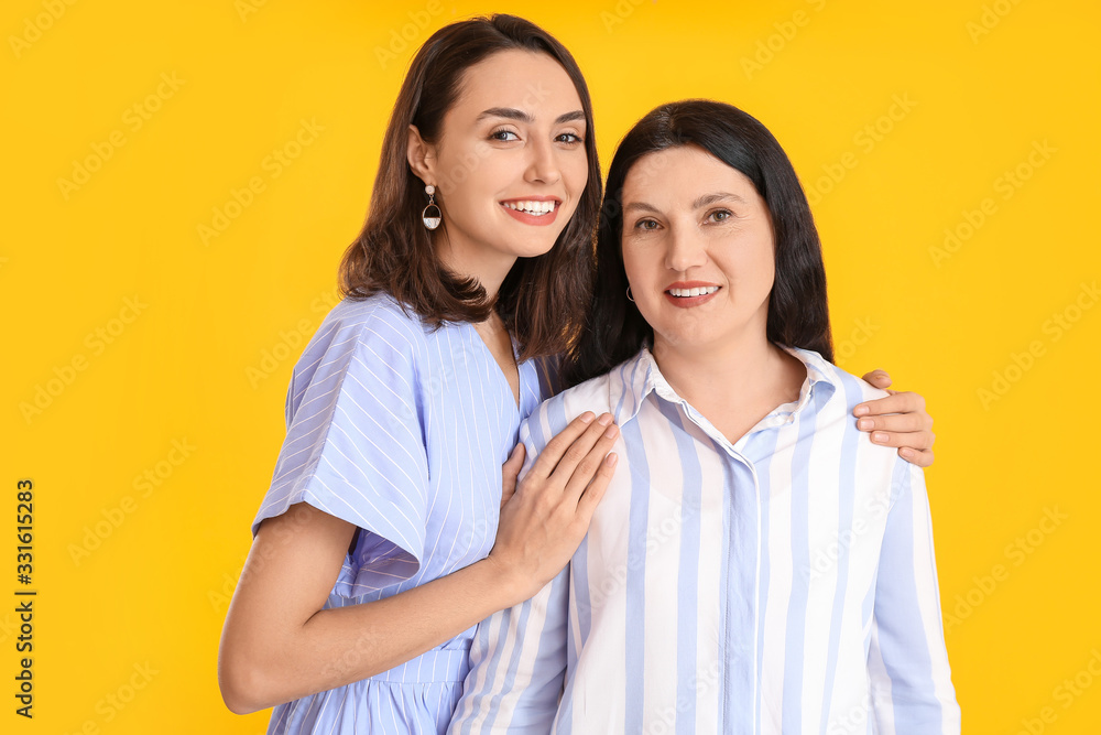 Portrait of adult daughter and her mother on color background Portrait of adult daughter and her mother on color background