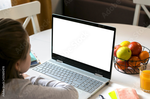 Schoolgirl studying at home using laptop. Home school, online education, home education, quarantine, coronavirus concept. Mockup concept.