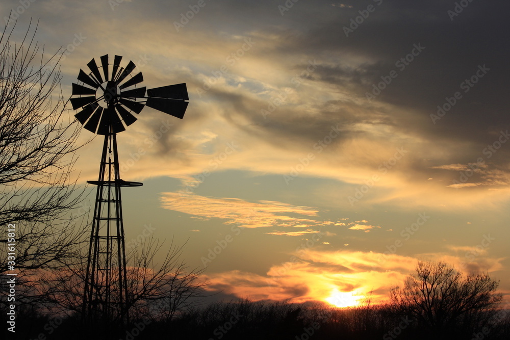 Kansas colorful Sunset with a Windmill silhouette out in the country. Kansas colorful Sunset with a Windmill silhouette out in the country.