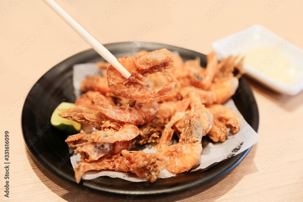 Izakaya Fried shrimp with chopsticks on white background Izakaya Fried shrimp with chopsticks on white background
