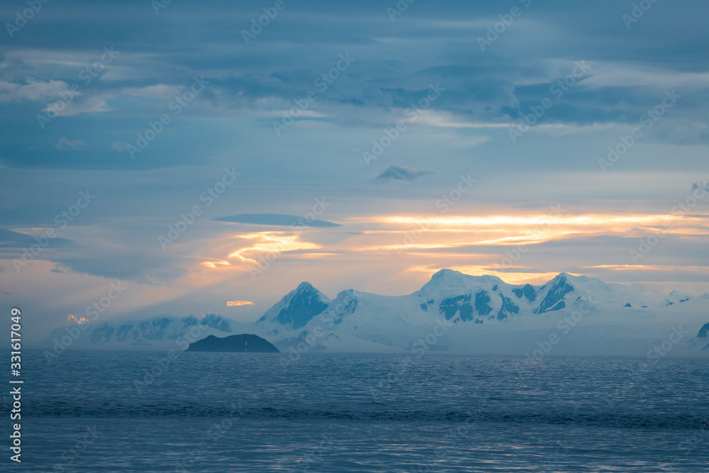 sunset over the sea, landscape in Antarctica with mountains and glaciers 