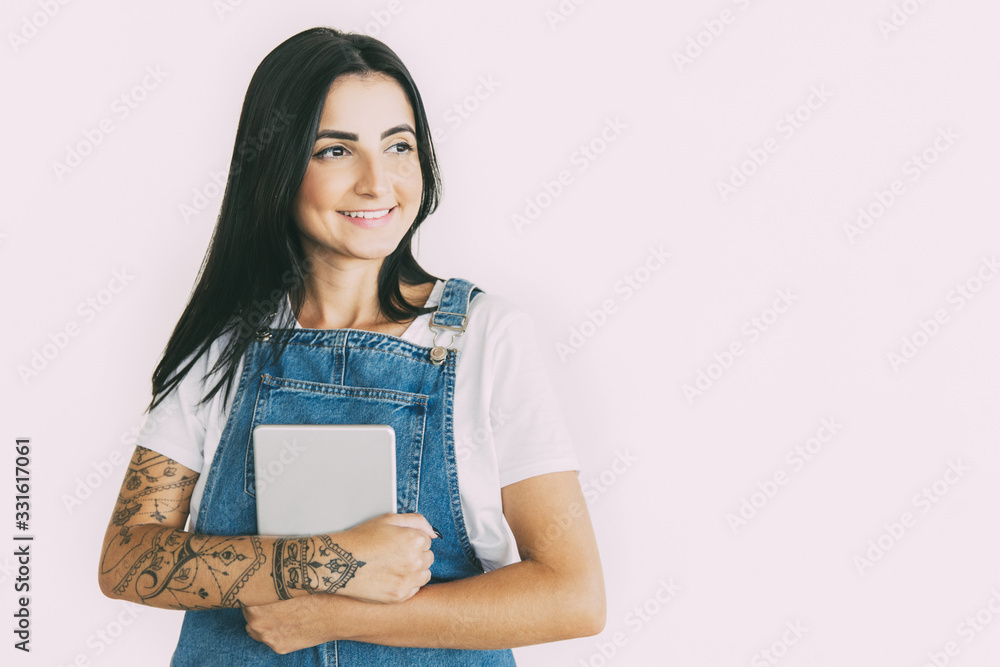 Smiling young woman with digital tablet. Beautiful young tattooed woman holding tablet computer and looking away isolated on white background. Technology concept Smiling young woman with digital tablet. Beautiful young tattooed woman holding tablet computer and looking away isolated on white background. Technology concept