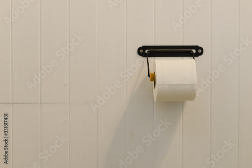 soft toilet paper roll on white wall in bathroom with copy space