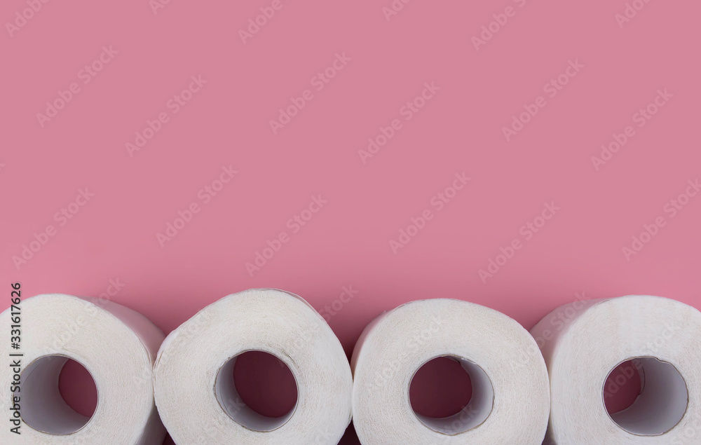 .Rolls of white toilet paper on a pink background copy space. Shortage of toilet paper flat lay. .Rolls of white toilet paper on a pink background copy space. Shortage of toilet paper flat lay.