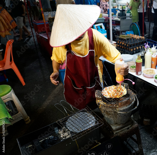 Thai Woman prepares Vietnamese pizza night market