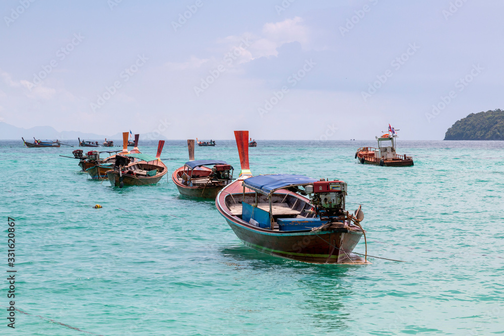 Traditional long tail boat on white sand beach in Thailand. Travel and Holiday concept, Tropical beach, long tail boats, gulf of Thailand. Long boat and tropical beach, Andaman Sea.