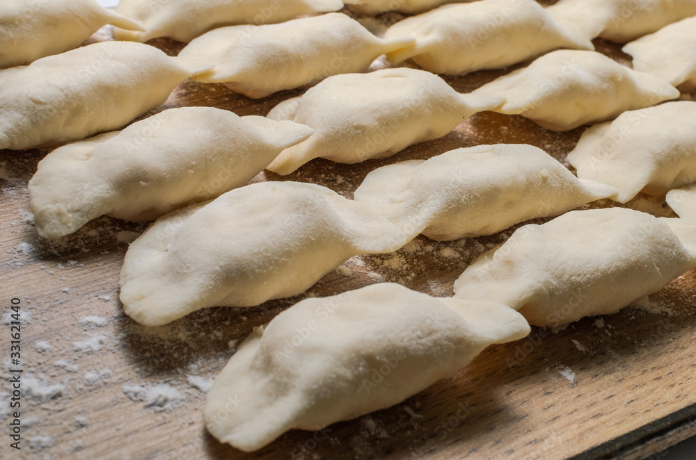 Raw dumplings made of dough in handmade flour Raw dumplings made of dough in handmade flour