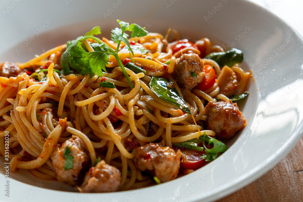 Selective focus, Spaghetti pasta with meatballs and tomato sauce. spaghetti and meatballs with oregano garnish on white plate. Spicy Spaghetti pasta with meatballs and spicy sauce. Selective focus, Spaghetti pasta with meatballs and tomato sauce. spaghetti and meatballs with oregano garnish on white plate. Spicy Spaghetti pasta with meatballs and spicy sauce.