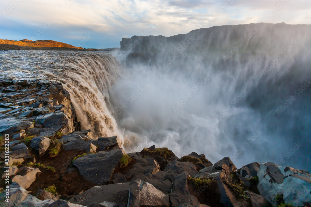 Beautiful Icelandic waterfall at sunset with huge quantity of flowing waters Iceland