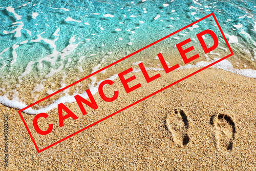 Foot prints on beach sand, blue sea wave landscape, red CANCELLED stamp, Coronavirus pandemic, covid 19 epidemic, cancellation symbol, ban sign, emergency situation banner, travel cancelled concept photo