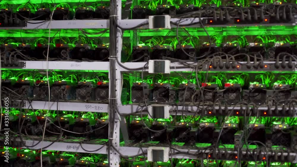 Cryptocurrency mining equipment on large farm. ASIC miners on stand racks mine bitcoin in server room. Blockchain techology application specific integrated circuit. Tripod panorama. Cryptocurrency mining equipment on large farm. ASIC miners on stand racks mine bitcoin in server room. Blockchain techology application specific integrated circuit. Tripod panorama.