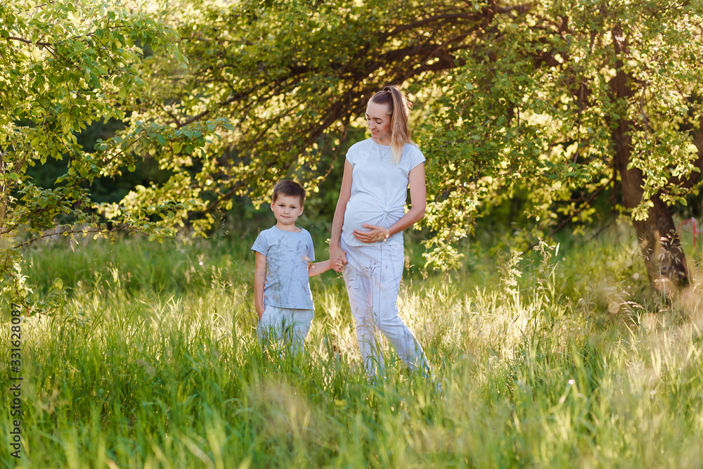 pregnant woman and child at a summer photo shoot pregnant woman and child at a summer photo shoot