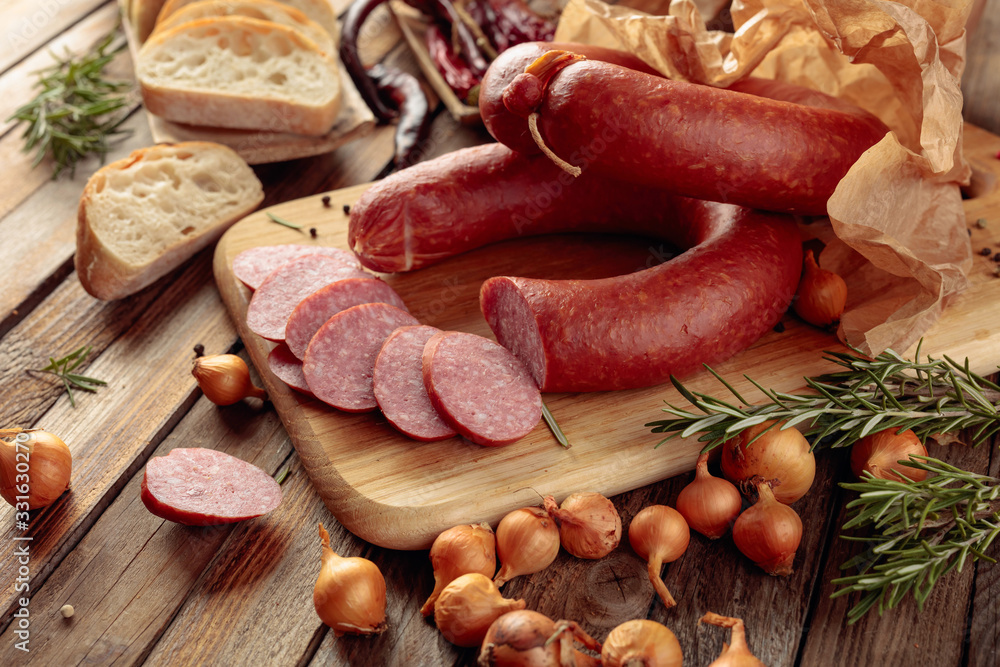 Smoked sausage with bread and spices on a old wooden table. Smoked sausage with bread and spices on a old wooden table.