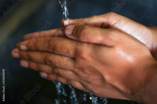Washing hands under flowing tap water