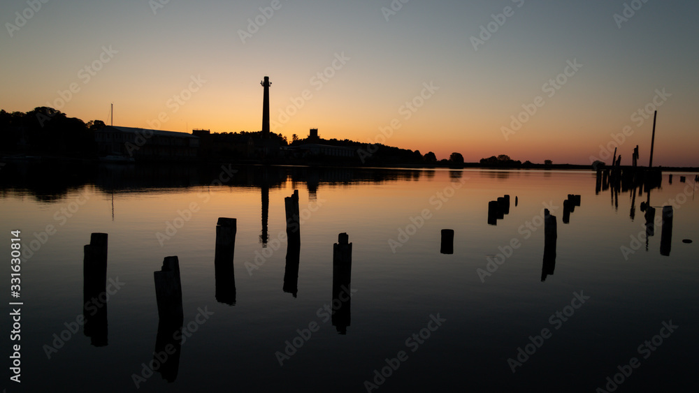 Sunset at sea port. beautiful shadows of old pier wooden pillars