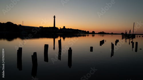 Sunset at sea port. beautiful shadows of old pier wooden pillars