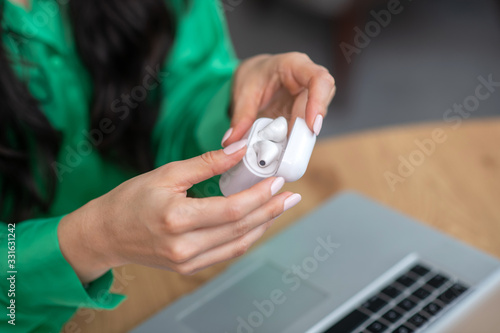 Wireless white headphones in beautiful female hands.