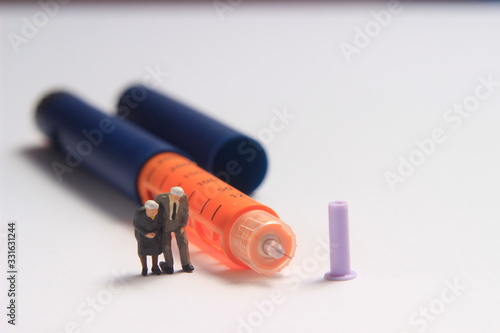 Photo Walking Mini Figure Toy Sitting Beyond Insulin Pen at White Background