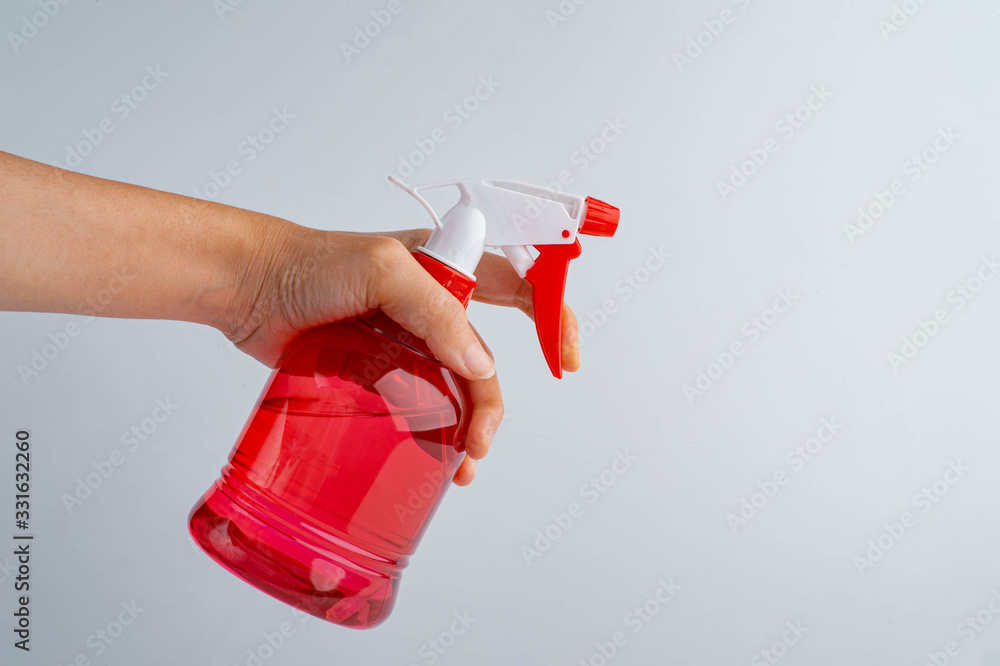 Naklejka premium spray bottle in hand, isolated on white background