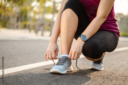 closeup of young woman runner tying her shoelaces. healthy and fitness concept.