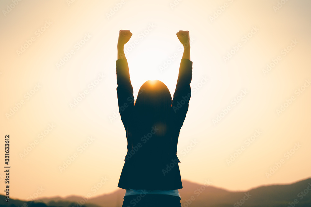 Successful young businesswoman raising arm celebrating business or job achievement Successful young businesswoman raising arm celebrating business or job achievement