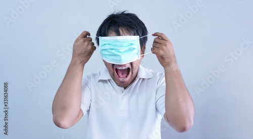 Asian  Man in medical mask  Coronavirus pandemic disease on grey background. COVID-19 virus from China epidemic outbreak to global recession concept for person social  air pollution   Respiratory illness