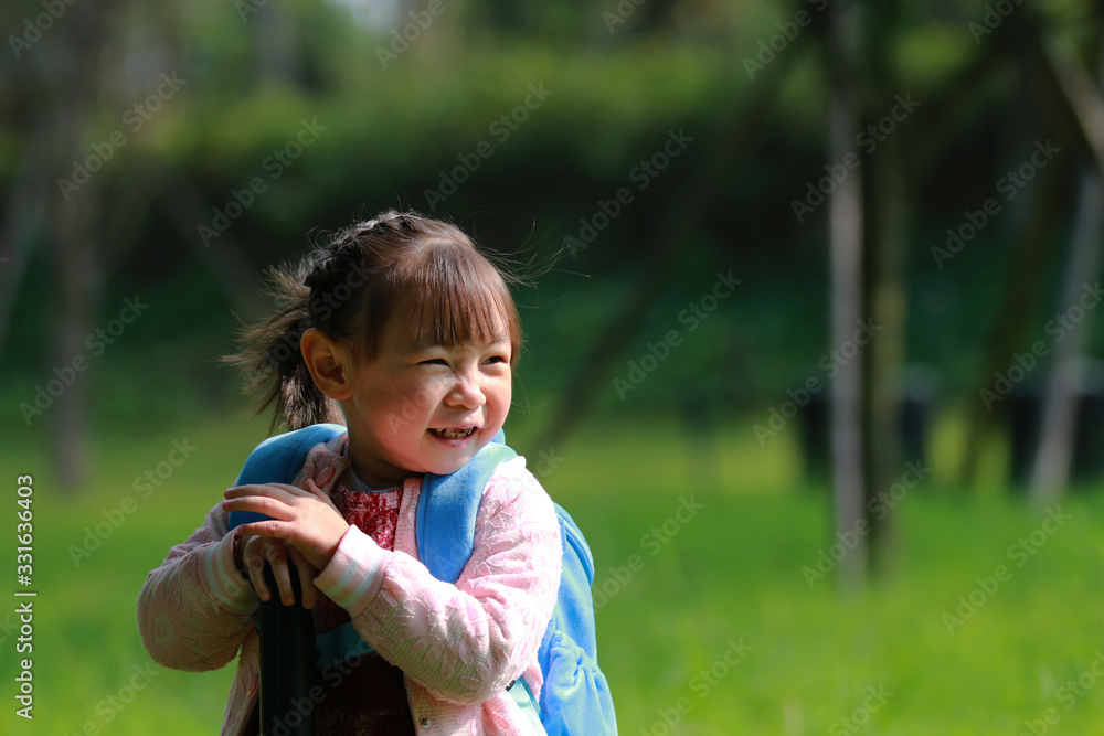 A little girl playing happily on the grass in the park A little girl playing happily on the grass in the park