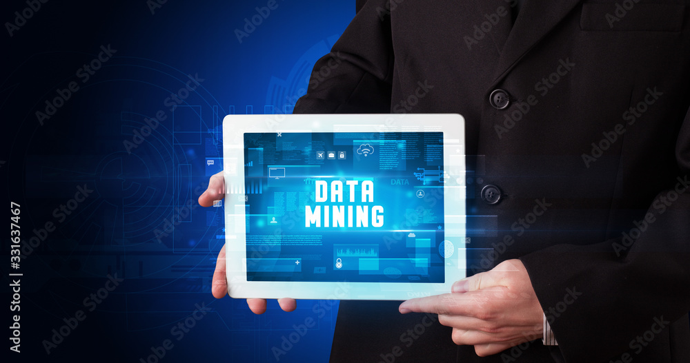 Young business person working on tablet and shows the digital sign: DATA MINING Young business person working on tablet and shows the digital sign: DATA MINING