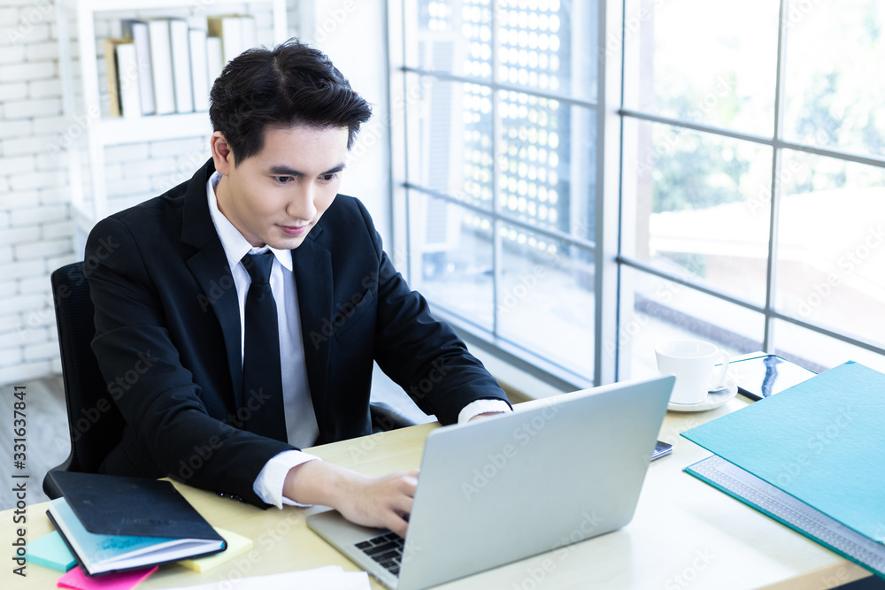 Happy of asian young businessman see a successful business plan on the laptop computer and pen on wooden table background in office,business expressed confidence embolden Happy of asian young businessman see a successful business plan on the laptop computer and pen on wooden table background in office,business expressed confidence embolden
