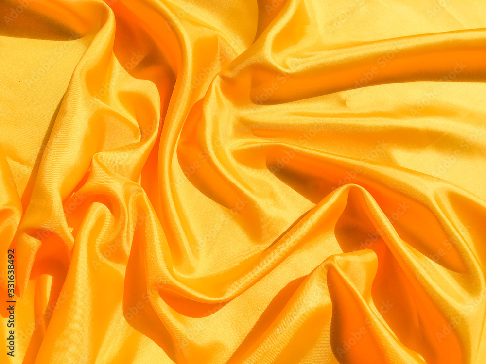 Bright yellow silk with waves moving for background. Abstract design with copy space Bright yellow silk with waves moving for background. Abstract design with copy space