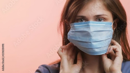head of a young woman wearing a mask on her face and mouth on a studio background, concept of protection methods against a pandemic of disease, stop spread of infection