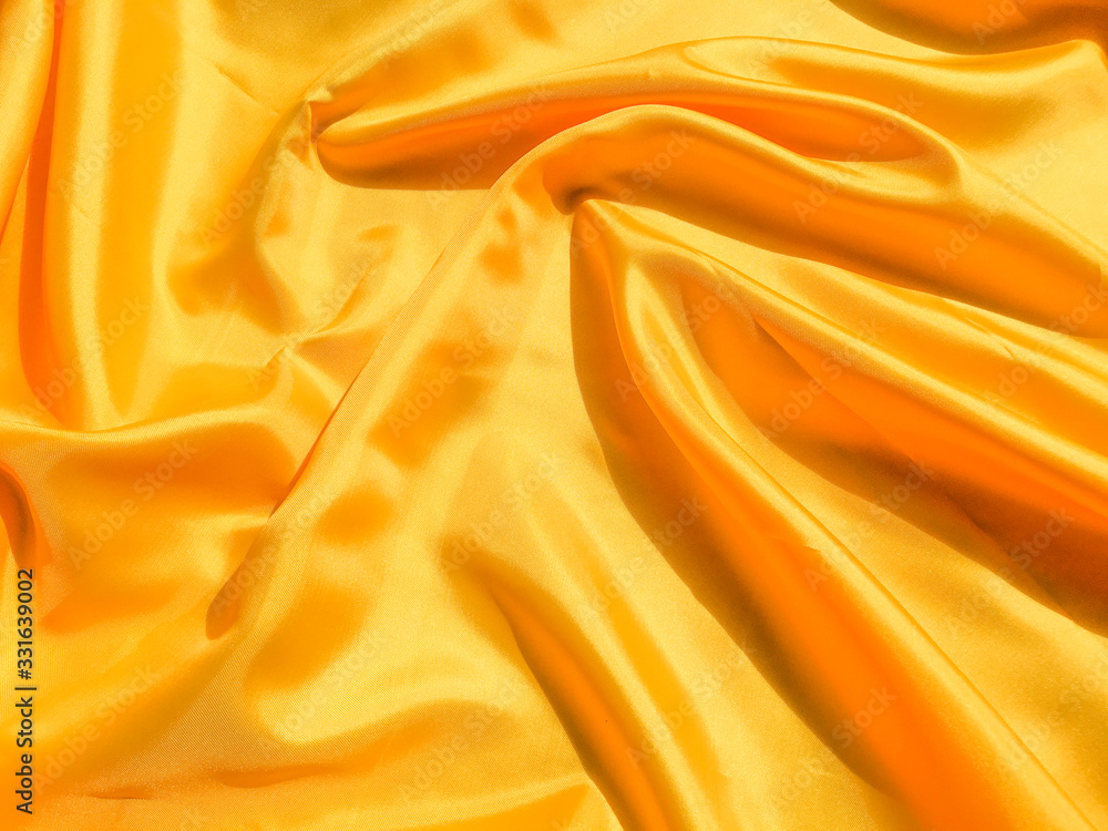 Bright yellow silk with waves moving for background. Abstract design with copy space Bright yellow silk with waves moving for background. Abstract design with copy space