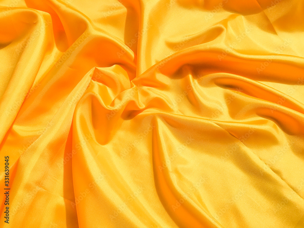 Bright yellow silk with waves moving for background. Abstract design with copy space Bright yellow silk with waves moving for background. Abstract design with copy space