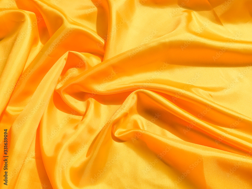 Bright yellow silk with waves moving for background. Abstract design with copy space Bright yellow silk with waves moving for background. Abstract design with copy space