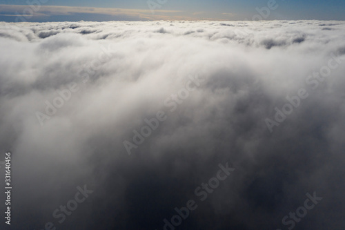 Aerial view White clouds in blue sky. View from drone. Aerial top view cloudscape. Texture of clouds. View from above. Sunrise or sunset over clouds. Panorama clouds © Aleksei