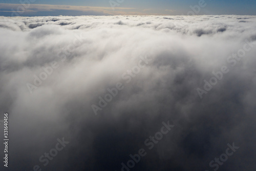 Aerial view White clouds in blue sky. View from drone. Aerial top view cloudscape. Texture of clouds. View from above. Sunrise or sunset over clouds. Panorama clouds