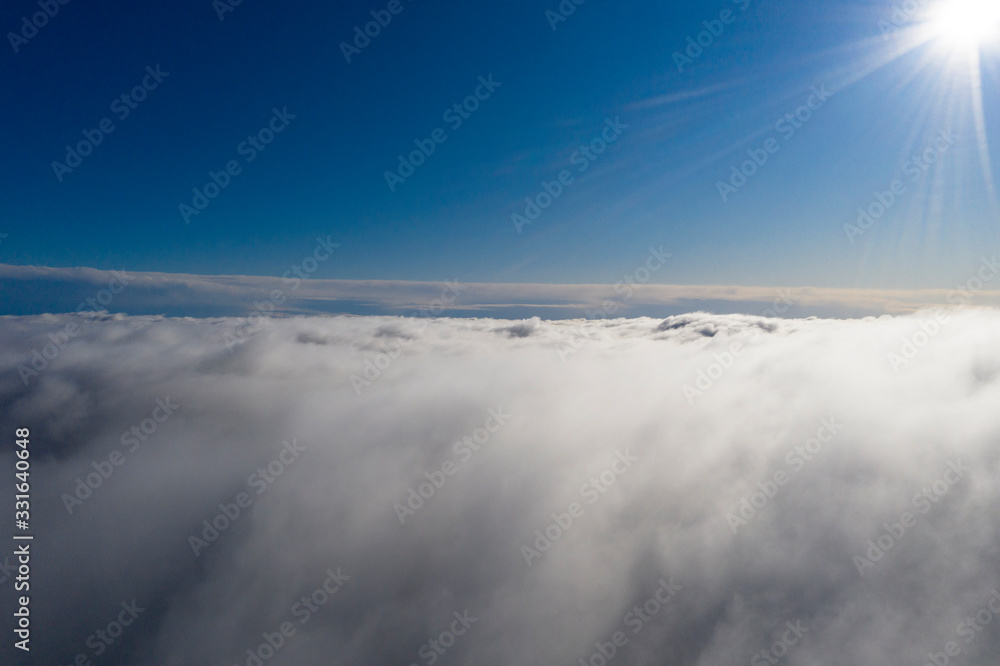 Aerial view White clouds in blue sky. View from drone. Aerial top view cloudscape. Texture of clouds. View from above. Sunrise or sunset over clouds. Panorama clouds