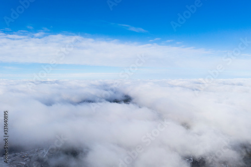 Aerial view White clouds in blue sky. View from drone. Aerial top view cloudscape. Texture of clouds. View from above. Sunrise or sunset over clouds. Panorama clouds