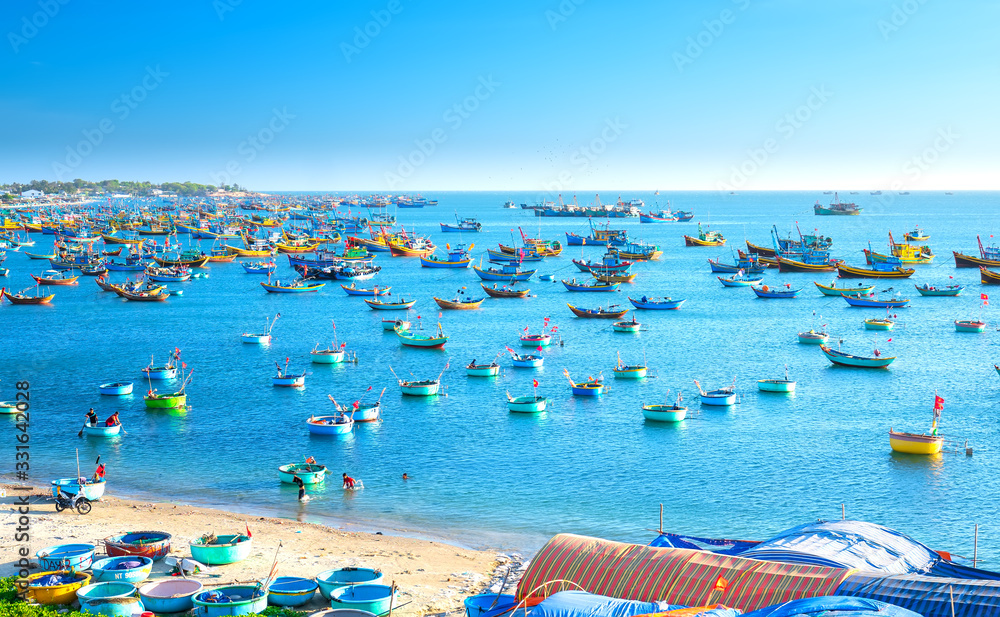 Fishing village and traditional fishing boat with hundreds boats anchored in sunny moring. This is bay for boats avoid rainy season storms in Mui Ne, Vietnam