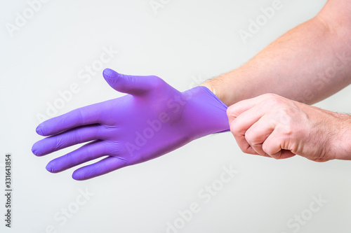 Male hand pulling a glove on